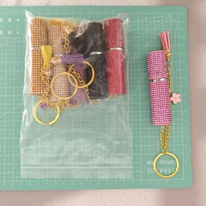 Macro detail of sparkly rhinestone perfume bottle keychains with leather tassels and gold rings