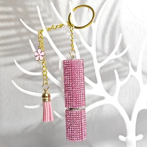 Pink rhinestone lipstick keychain with gold keyring, delicate flower and suede tassel