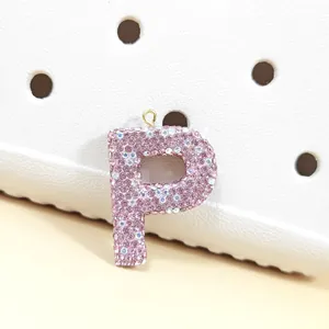 Gros plan du pendentif lettre P en strass rose étincelant avec anneau doré