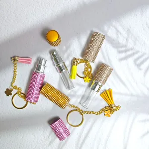 Glittering rhinestone perfume bottle keychains in pink, yellow and champagne with tassels