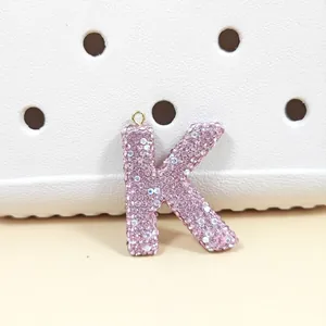 Vue macro du porte-clés lettre K en strass roses et décoration pour sacs à main