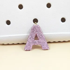 Vue détaillée du pendentif lettre A en strass roses avec anneau en métal doré