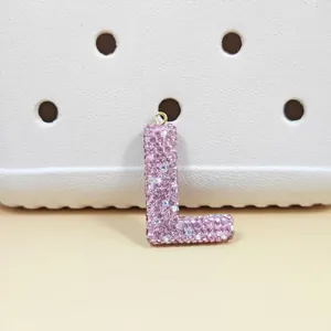 Gros plan du pendentif lettre L rose serti de strass brillants et anneau doré