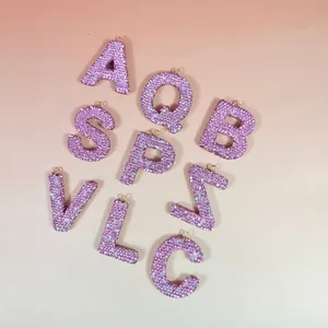 Détail macro de lettres incrustées de strass roses avec base en métal doré pour DIY