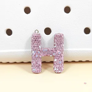 Gros plan d'un charm lettre H en strass rose scintillant pour sacs et chaussures