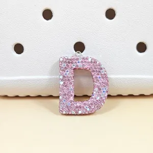 Vue détaillée du pendentif lettre D orné de strass roses sur cuir blanc