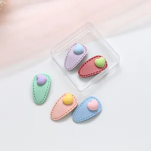 Vue détaillée de barrettes à cheveux cœur macaron avec texture daim et boîte de rangement