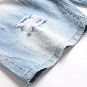 Distressed detail of light blue denim shorts with frayed edges and washed finish
