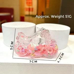 Dettaglio portachiavi a forma di moto con paillettes rosa e decorazioni glitterate