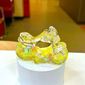 Detail of yellow motorcycle crystal bottle keychain with floating colorful glitter inside