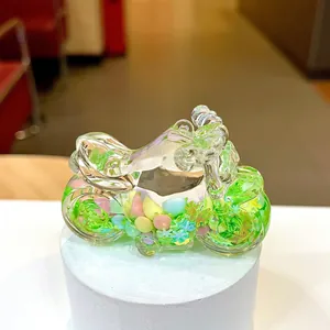 Macro shot of glass motorcycle bottle with colorful stones and miniature moss landscape