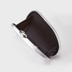 Détail d'une pochette de soirée argentée avec doublure noire et fermoir ovale