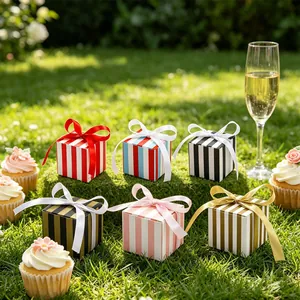 Detailed view of colorful striped gift boxes with satin bows on lush green grass