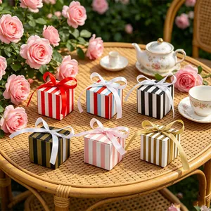 Detailed view of colorful striped gift boxes with ribbon bows on a decorated outdoor table