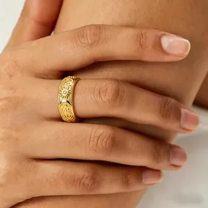 Detailed close-up of a gold embossed sun and moon ring with sparkling zircon stones