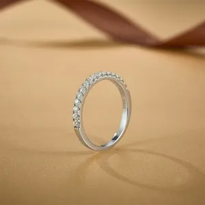 S925 sterling silver half eternity ring with sparkling moissanite stones on gold surface