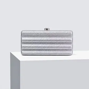 Close-up of silver glitter evening bag with wavy ridges and square metal clasp