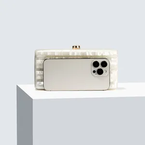 Internal capacity of white pearlescent acrylic clutch bag showing it fits a smartphone