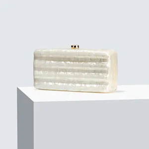 Detailed view of pearlescent marble texture acrylic evening clutch with gold clasp