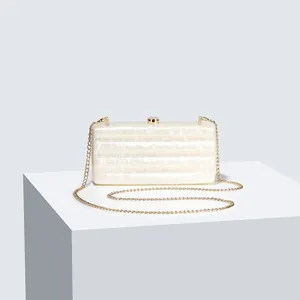 Detail of creamy white marble texture acrylic evening bag with gold chain strap