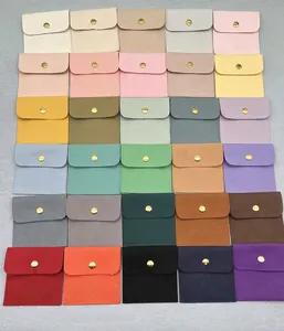 Flat lay of 30 color options for microfiber jewelry envelopes with gold snap buttons