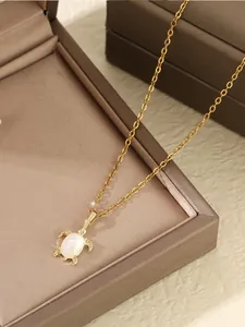 Détail du collier pendentif tortue dorée avec incrustation d'opale sur boîte à bijoux
