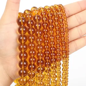 Strands of translucent amber-colored glass beads in various sizes for jewelry making