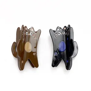 Vue détaillée de deux pinces à cheveux chat en acétate, couleurs marron et noir