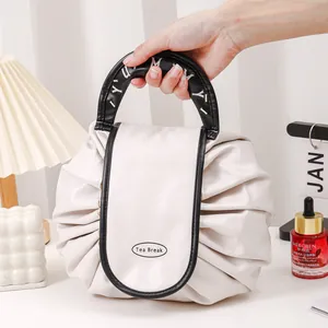 Sac cosmétique crème avec poignées noires et logo Tea Break pour rangement voyage