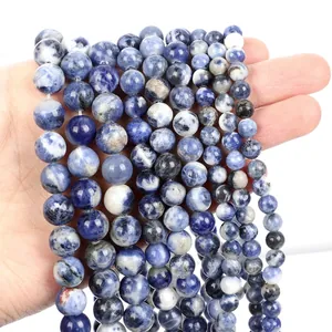 Macro shot of polished blue sodalite natural stone beads with white marble textures