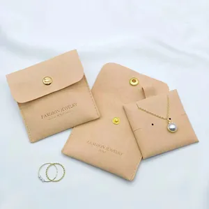 Detail of peach microfiber jewelry pouch featuring a snap button and gold engraving