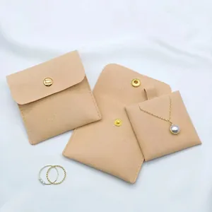 Detail of peach microfiber jewelry pouch featuring a snap button and gold engraving