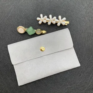 Close-up of pearl flower hair clips and resin star pins with a grey velvet jewelry bag