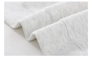 Detail von hellgrauem Strickstoff mit Rippbündchen und glatten Nähten für Hoodies