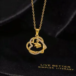 Detail of gold heart pendant with crystal inlay, mortarboard charm and engraved motto