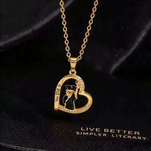 Macro shot of gold heart pendant with panda in graduation cap and You Did It engraving