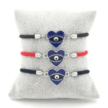 Close-up of woven rope bracelets in black red and blue with heart evil eye charms