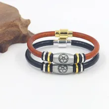 Close-up detail of soccer themed braided leather bracelets with metallic charms and magnetic clasp