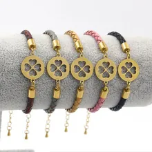 Detail of woven leather bracelets with gold clover charms in five different colors