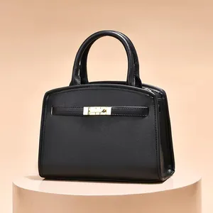 Elegant black structured handbag with gold rectangular buckle and twin top handles