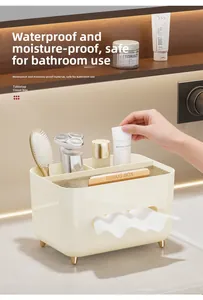 Macro view of cream tissue box with gold feet holding toiletries on marble counter