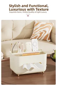 Cream tissue box with gold legs and compartments for remotes and stationery on a table