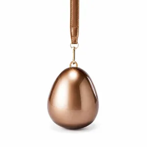 Close-up of polished egg-shaped acrylic evening bag with metallic rose gold finish