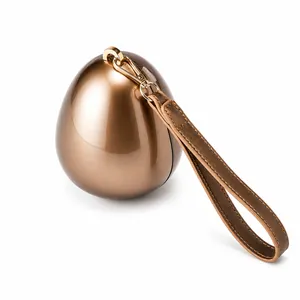 Detailed macro of bronze egg-shaped evening bag with metallic finish and leather handle