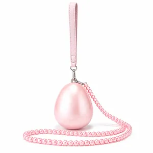 Detailed view of pink egg-shaped acrylic clutch with pearl strap and glossy shell finish