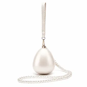 Detailed macro view of the egg-shaped clutch featuring a pearl sheen and gold metal clasp