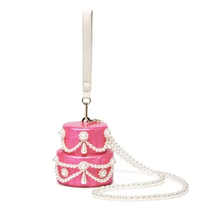 Close-up of pink shell acrylic evening bag featuring layered pearl tassels and marble finish