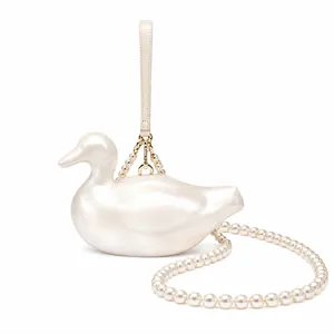 Detail of creative duck-shaped acrylic bag with pearl crossbody chain and golden hardware