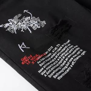 Jean noir délavé coupe slim avec broderie graffiti blanche et rouge pour un look urbain