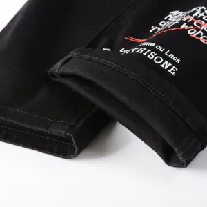 Jean noir slim avec broderie graffiti blanche et détails de lignes rouges urbains